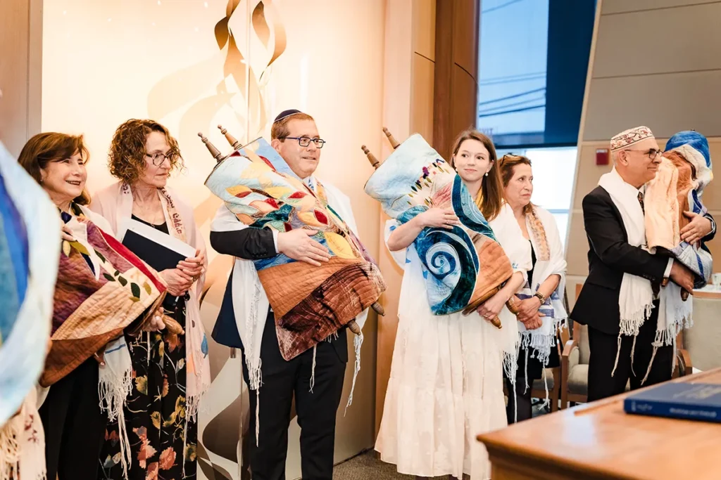 people holding the torah for morning Shabbat services