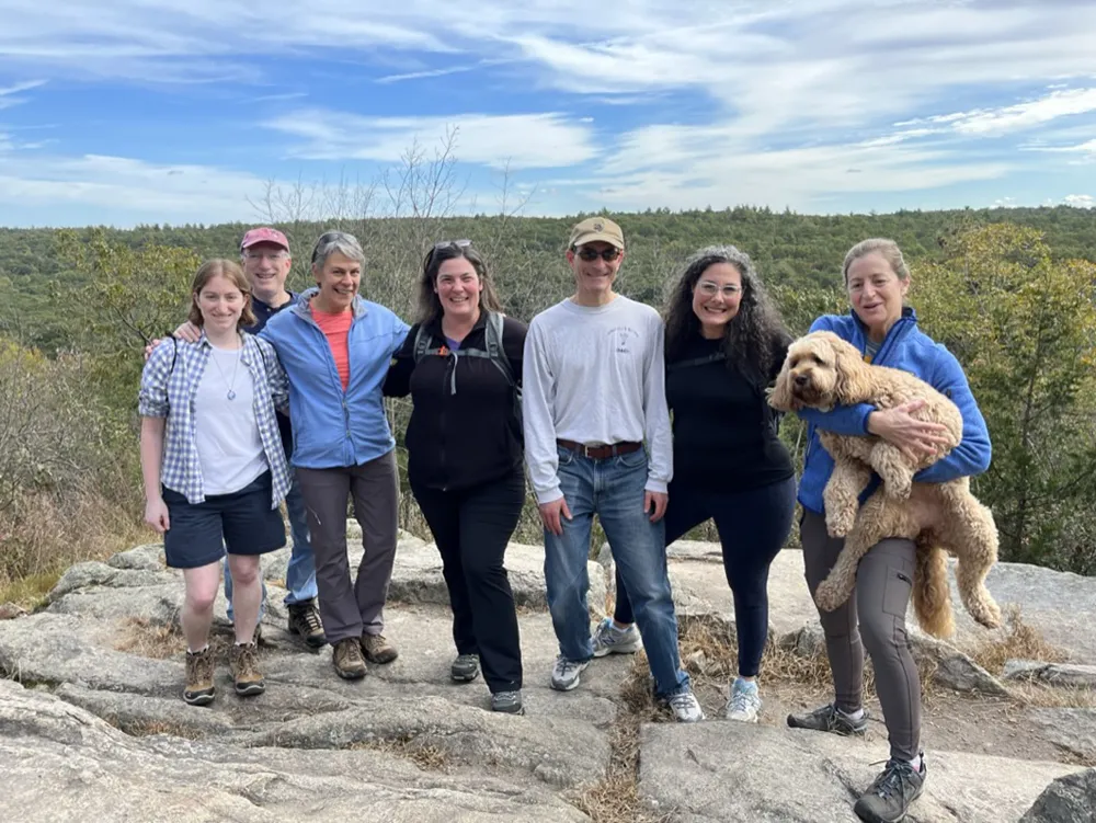 group of people on an over look point of a hike posing for a photo